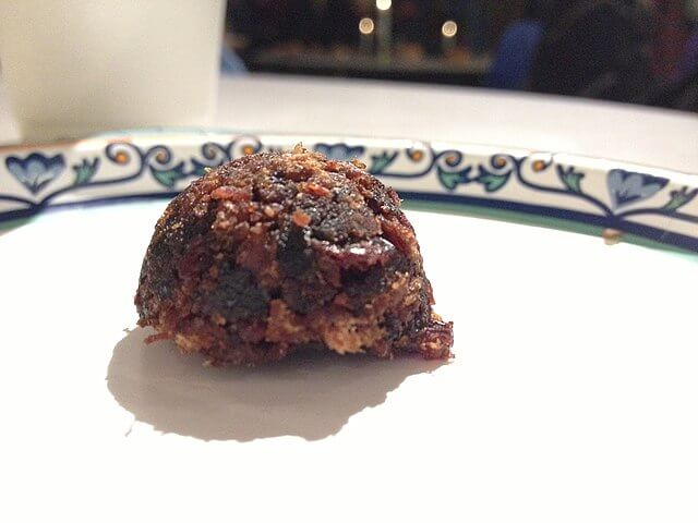 A plate with a rounded ball of pemmican. Pieces of fruit can be seen in the mix.